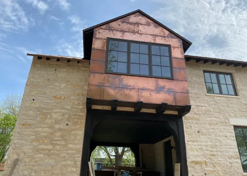 Copper metal panel facade on a stone building for Skylight Installation in Brookings